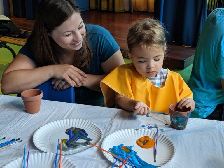 Adult and child painting on a terracotta pot